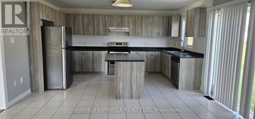 Southgate apartment for rent - A kitchen with a refrigerator, sink, and cabinets.