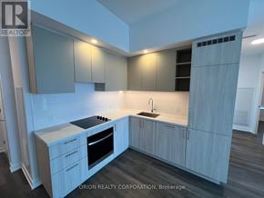 Vaughan (Vaughan Corporate Centre) condo for rent - A modern kitchen with a sink, stove, and cabinets.