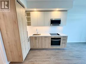 Vaughan (Vaughan Corporate Centre) condo for rent - A kitchen with wooden cabinets and a sink.
