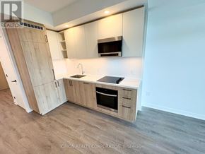 Vaughan (Vaughan Corporate Centre) condo for rent - A kitchen with wooden cabinets and a microwave above the stove.