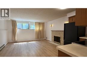 Vancouver apartment for rent - A living room with a fireplace and a kitchen area.