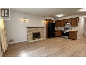 Vancouver apartment for rent - A living room with a fireplace and a kitchenette in the background.