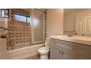Vancouver apartment for rent - A bathroom with a toilet, sink, and a shower with a glass door.