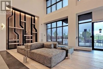 Toronto (Downsview-Roding-Cfb) townhouse for rent - A modern living room with a large sectional sofa and a wooden floor.
