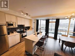 Toronto (Downsview-Roding-Cfb) townhouse for rent - A modern kitchen with wooden floors and stainless steel appliances.