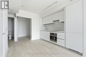 Toronto (Thorncliffe Park) condo for rent - A white kitchen with a sink and a refrigerator.