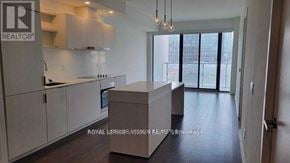 Toronto (Waterfront Communities) condo for rent - A modern kitchen with white cabinets and a large island.