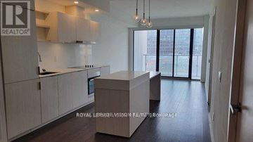 Toronto (Waterfront Communities) condo for rent - A modern kitchen with white cabinets and a large island.