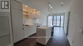 Toronto (Waterfront Communities) condo for rent - A modern kitchen with white cabinets and a large island.