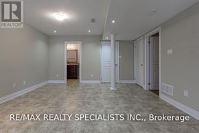 Mississauga (East Credit) apartment for rent - A spacious room with a doorway leading to another room, and a logo of RE/MAX Realty Specialists Inc. on the bottom left.