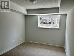 Toronto (New Toronto) townhouse for rent - A room with a window and a carpeted floor.