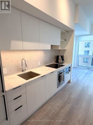 Toronto (Church-Yonge Corridor) condo for rent - A modern kitchen with white cabinets and a marble countertop.
