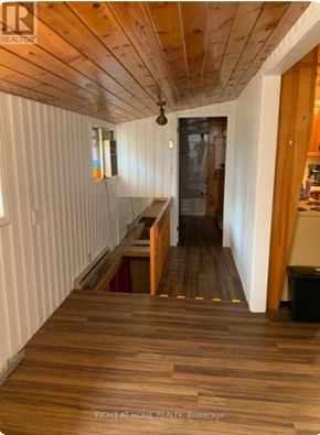 Tiny apartment for rent - A hallway with wooden floors and white walls.