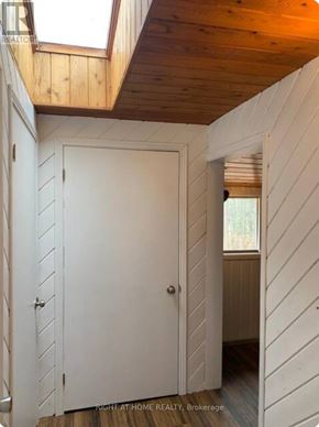 Tiny apartment for rent - A white door in a room with wooden walls and ceiling.