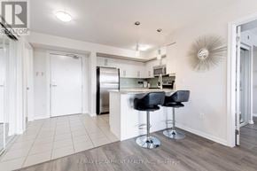 Milton (Wi Willmott) condo for rent - A kitchen with white cabinets and a bar area with black stools.
