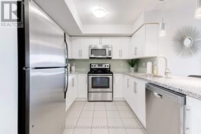 Milton (Wi Willmott) condo for rent - A kitchen with white cabinets and a stainless steel refrigerator.