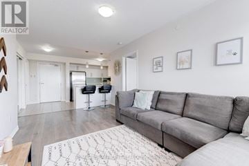 Milton (Wi Willmott) condo for rent - A living room with a grey couch and a rug with a pattern on it.