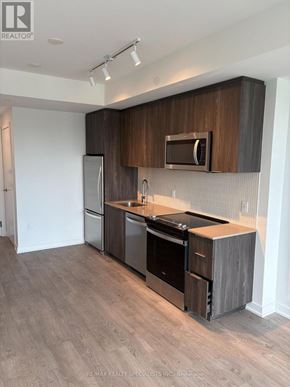 Milton (Cb Cobban) condo for rent - A modern kitchen with dark wood cabinets and stainless steel appliances.