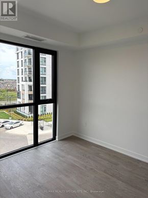 Milton (Cb Cobban) condo for rent - A room with a view of a parking lot and a building outside.