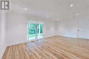 Toronto (Newtonbrook East) apartment for rent - A room with wooden flooring and a sliding glass door leading to a green outdoor area.