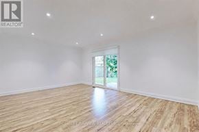 Toronto (Newtonbrook East) apartment for rent - A room with wooden flooring and a sliding glass door leading to a backyard.