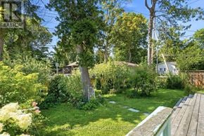 Tiny apartment for rent - A lush green garden with a wooden bench in the foreground.