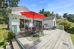 Tiny apartment for rent - A wooden deck with a table and chairs is in front of a house.