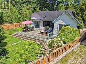 Tiny apartment for rent - A house with a deck and a pink umbrella.