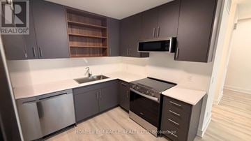 St. Catharines (Oakdale) townhouse for rent - A kitchen with dark brown cabinets and stainless steel appliances.