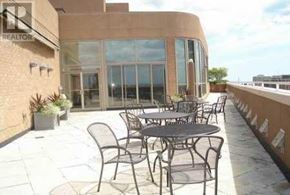 Toronto (Bay Street Corridor) condo for rent - A patio with a table and chairs is in front of a building.