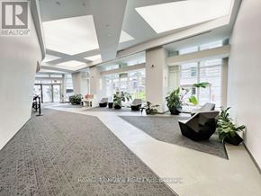 Toronto (Waterfront Communities) condo for rent - A spacious office lobby with a grey carpet and white walls.