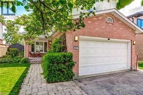 Waterdown apartment for rent - A red brick house with a white garage door and a number 16 on it.