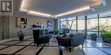 Richmond Hill (Harding) condo for rent - A living room with a black couch and a white coffee table.