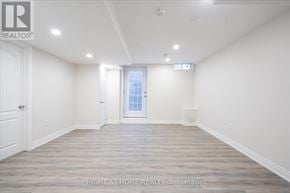 Oshawa (Taunton) apartment for rent - A spacious room with wooden flooring and white walls, with a door leading to another room.