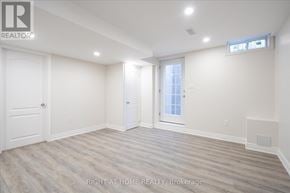 Oshawa (Taunton) apartment for rent - A spacious room with wood flooring and white walls.