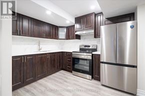 Oshawa (Taunton) apartment for rent - A kitchen with dark wood cabinets and stainless steel appliances.