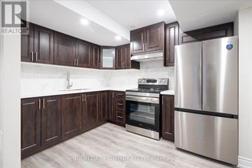 Oshawa (Taunton) apartment for rent - A kitchen with dark wood cabinets and stainless steel appliances.