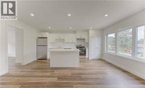 Kitchener apartment for rent - A spacious kitchen with white appliances and wooden flooring.