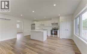 Kitchener apartment for rent - A spacious kitchen with wooden flooring and white cabinetry.