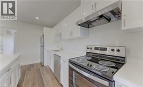 Kitchener apartment for rent - A modern kitchen with white cabinets and a stainless steel stove.