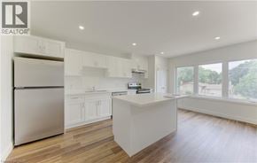 Kitchener apartment for rent - A modern kitchen with white cabinets and a wooden floor.