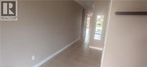 Guelph townhouse for rent - A long hallway with a Realtor sign on the wall.