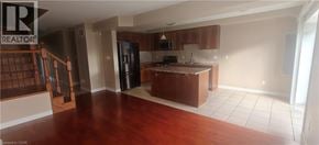 Guelph townhouse for rent - A kitchen with brown cabinets and a black refrigerator.