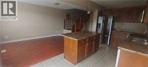 Guelph townhouse for rent - A kitchen with a refrigerator, sink, and cabinets.
