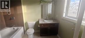 Guelph townhouse for rent - A bathroom with a toilet, sink, and bathtub.