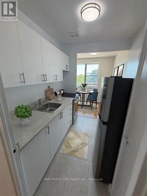 Toronto (Leaside) condo for rent - A kitchen with white cabinets and a black refrigerator.
