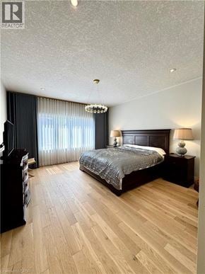 Kitchener apartment for rent - A bedroom with a large bed and wooden flooring.