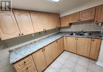 Toronto (Kennedy Park) apartment for rent - A kitchen with wooden cabinets and a marble countertop.
