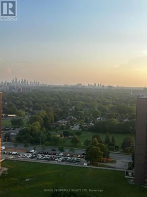Toronto (Etobicoke West Mall) condo for rent - A view of a city skyline from a high vantage point with a parking lot in the foreground.