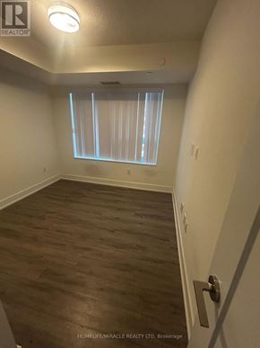 Toronto (Etobicoke West Mall) condo for rent - A room with wooden flooring and a window with blinds.